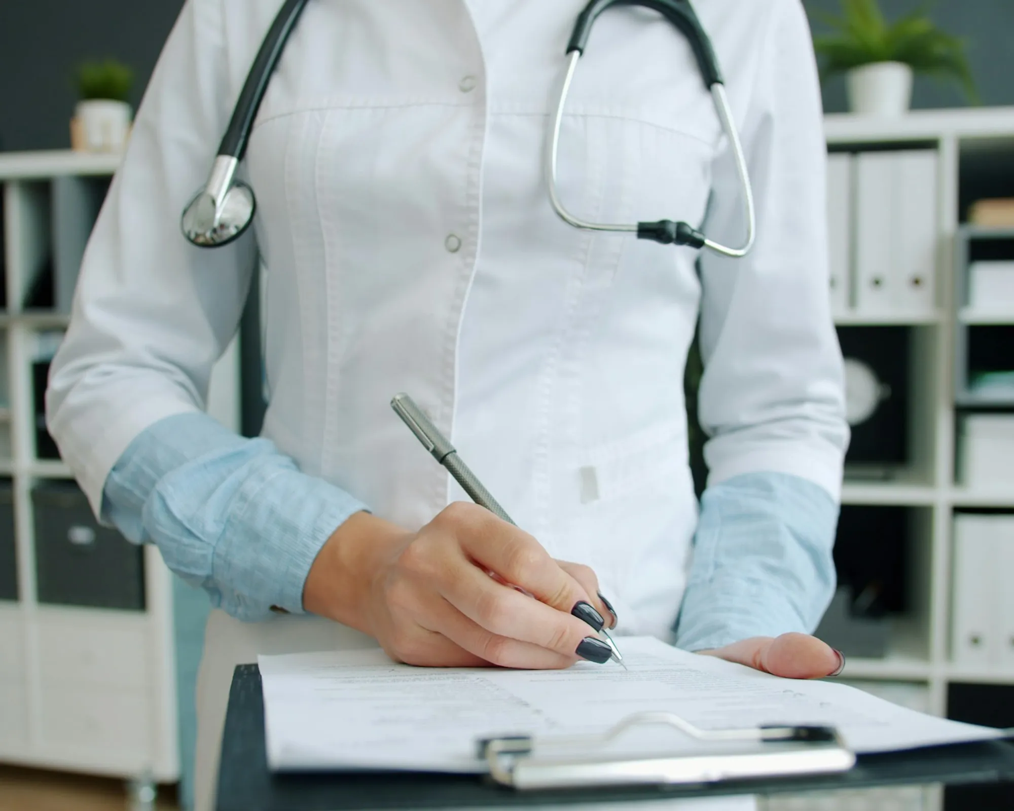 Physician writing educational clinical notes at an office desk