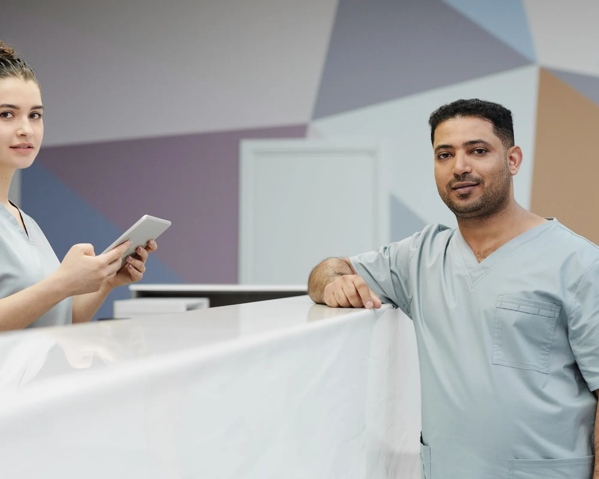 Clinic physician and receptionist coordinating patient care at the reception desk